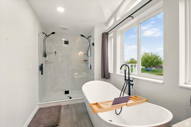 Bathroom featuring a marble finish shower, a soaking tub, and wood finished floors | Image 19