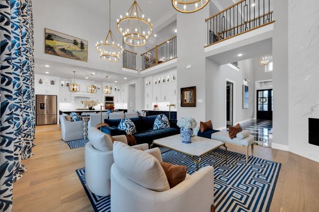 Living room with a towering ceiling, a chandelier, and light wood-type flooring | Image 14