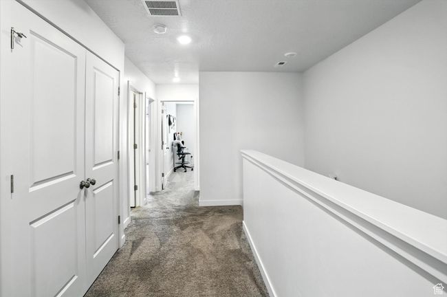 Carpeted hallway, an upstairs landing, and a textured ceiling | Image 17