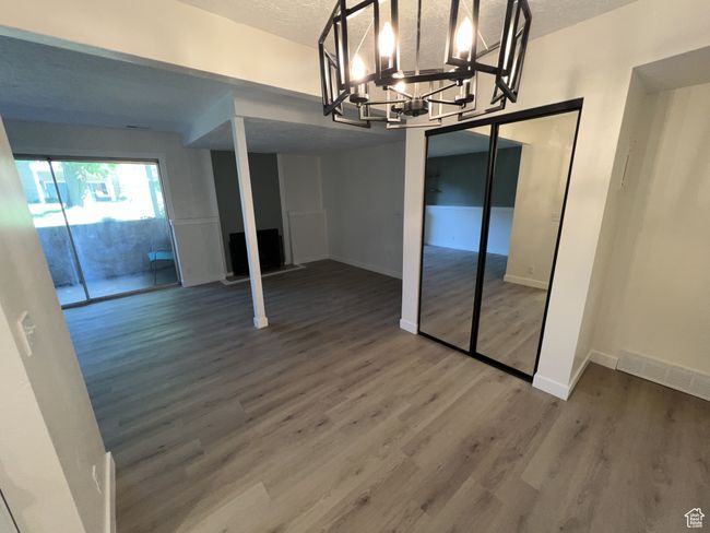 Unfurnished dining area featuring wood finished floors, baseboards, a chandelier, and a textured ceiling | Image 7