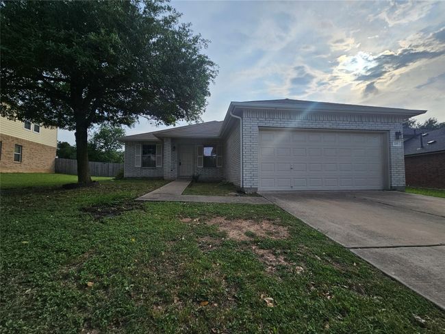 Single story home featuring concrete driveway, brick siding, and an attached garage | Image 4