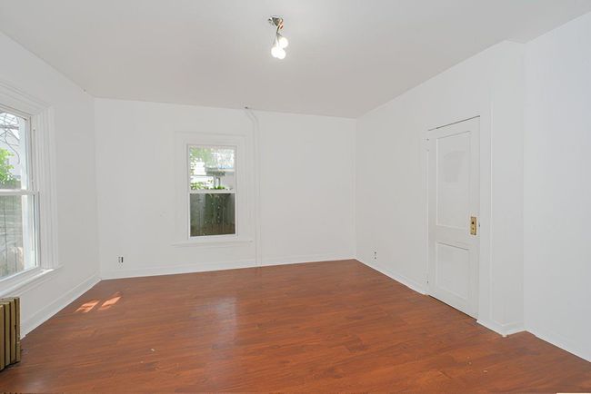 Unfurnished room with wood finished floors and radiator heating unit | Image 14