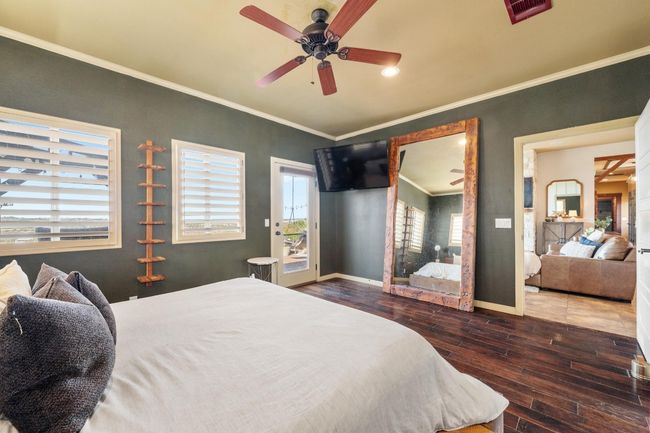 Bedroom with visible vents, crown molding, baseboards, access to outside, and wood finished floors | Image 17