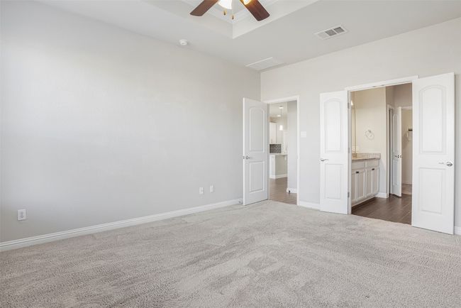 Unfurnished bedroom with dark carpet, connected bathroom, and a ceiling fan | Image 18
