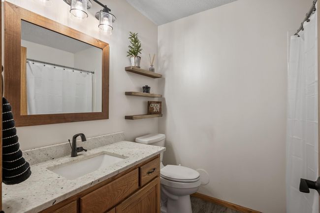 Nicely updated main floor bathroom with new sink, granite vanity top, tub and tile surround. | Image 31