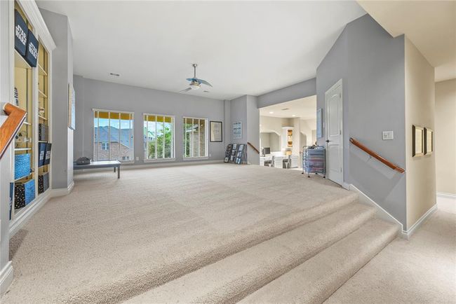 Second story landing leads to game room with built in shelves and windows that offer view to backyard. | Image 24