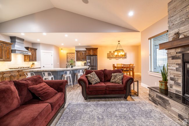 Living area with lofted ceiling, a chandelier, light wood-style floors, and recessed lighting | Image 13