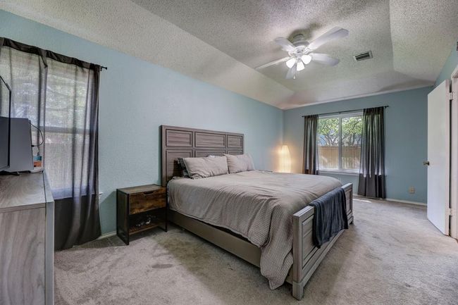 Bedroom featuring carpet, a textured ceiling, baseboards, and ceiling fan | Image 7
