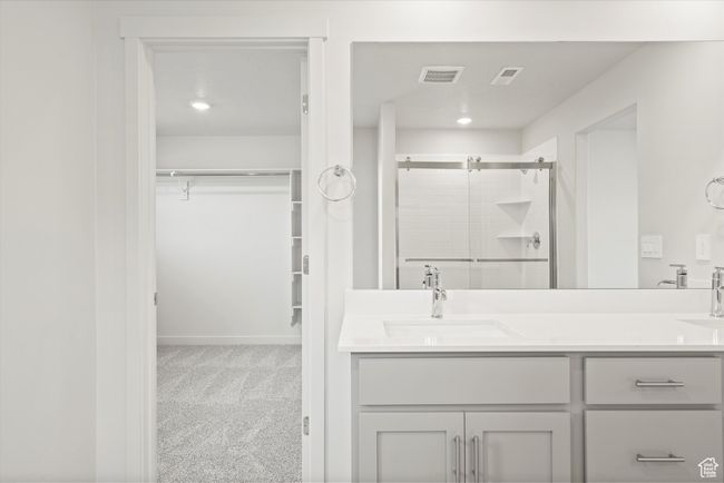 Bathroom featuring a shower stall, double vanity, and a spacious closet | Image 33