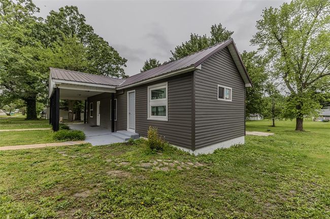 View of front of home featuring a front yard and metal roof | Image 55