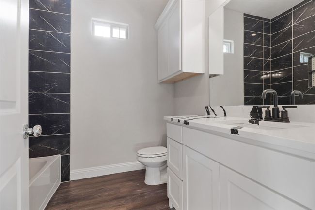 Full bath featuring toilet, vanity, wood finished floors, and baseboards | Image 15