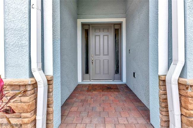 View of exterior entry with stucco siding and pavers | Image 8