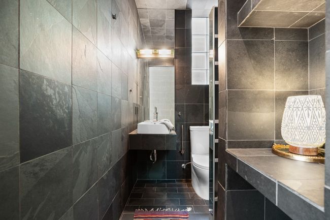 Downstairs full bathroom, with a custom art door, glass shower doors and privacy windows. | Image 32