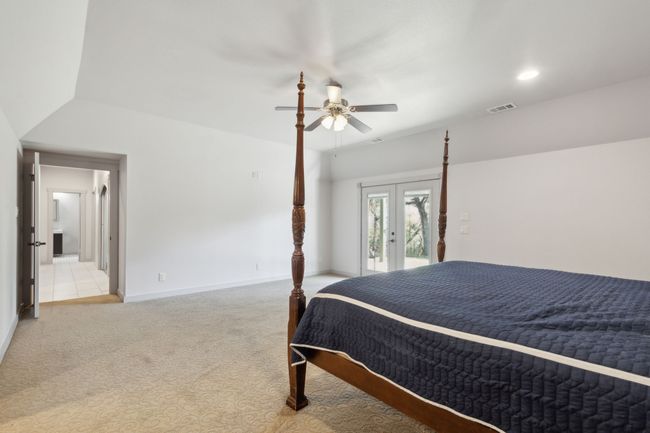 Carpeted bedroom featuring lofted ceiling, ceiling fan, access to exterior, and french doors | Image 22