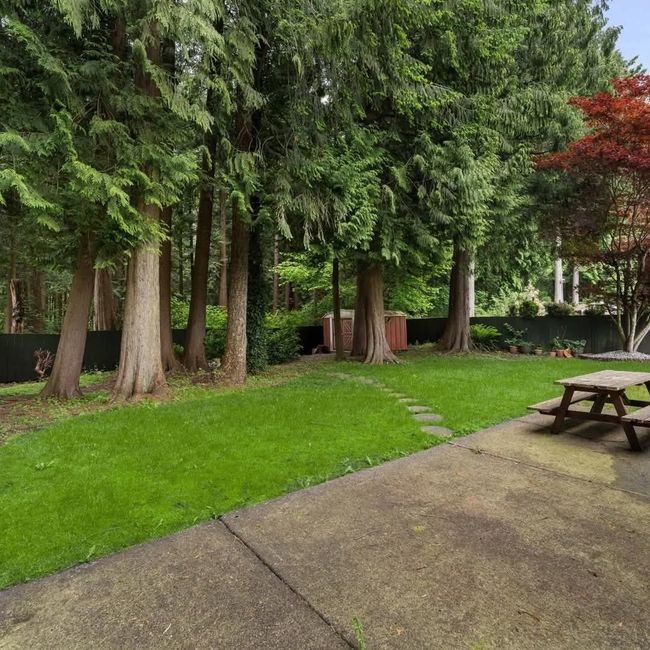 View of yard featuring an outdoor structure, a patio area, fence, and a shed | Image 4