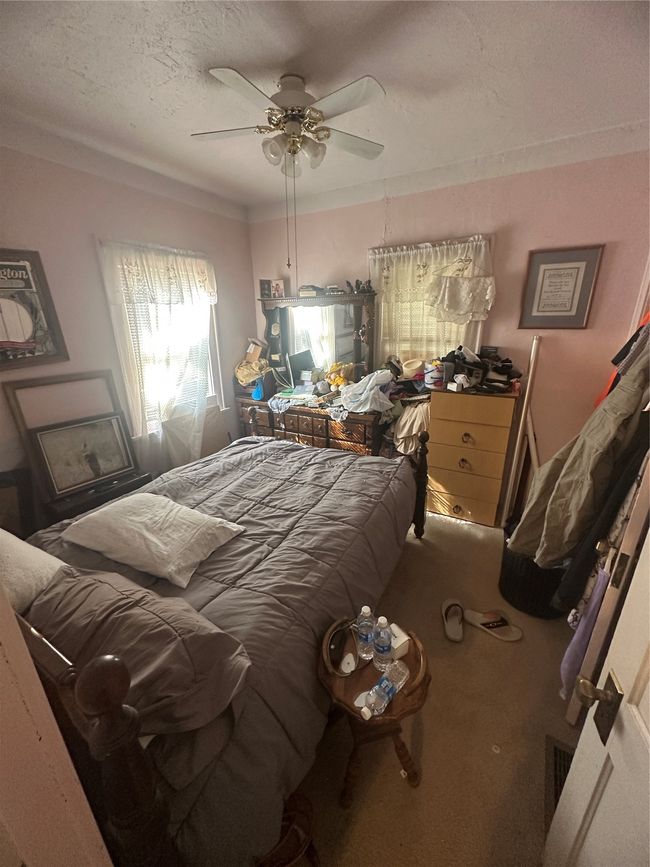 Main floor Bedroom with a textured ceiling, carpet, and ceiling fan | Image 7