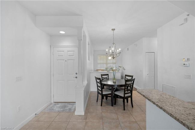 Dining area featuring light tile patterned floors, ornate columns, and an inviting chandelier | Image 7