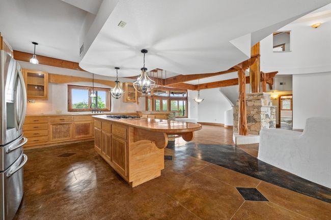 Kitchen featuring stainless steel appliances, a breakfast bar, a sink, a center island, and a chandelier | Image 8