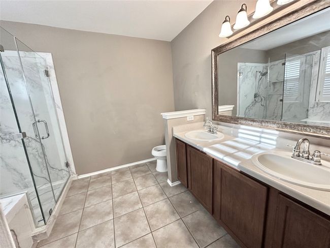 Bathroom with double vanity, a marble finish shower, and tile patterned flooring | Image 13