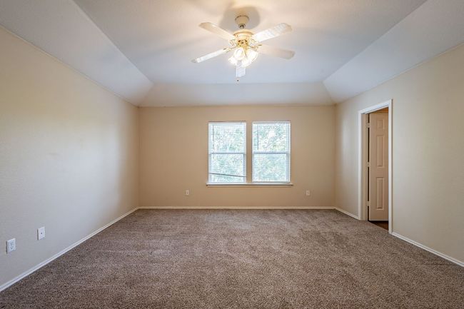 Carpeted spare room with ceiling fan, vaulted ceiling, and baseboards | Image 13
