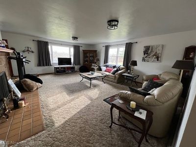 Living room with a fireplace and carpet flooring | Image 3