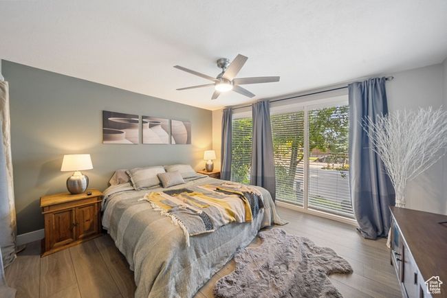 Bedroom featuring wood finished floors, access to exterior, and ceiling fan | Image 9