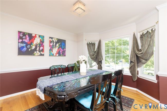 Dining room with crown molding and light wood finished floors | Image 5