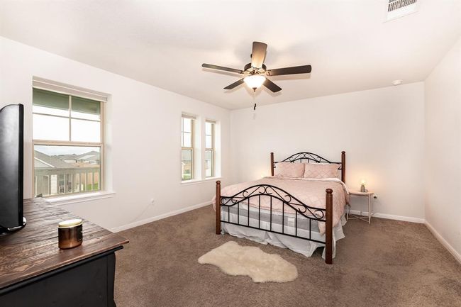 Bedroom with multiple windows, carpet flooring, and ceiling fan | Image 21