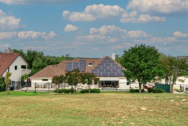 Back of property with a chimney, fence private yard, solar panels, and a lawn | Image 38