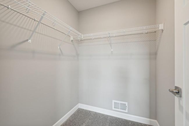 (Photo is of an inventory home, actual homes finishes will vary) The first of two walk-in closets in the primary bedroom. | Image 13