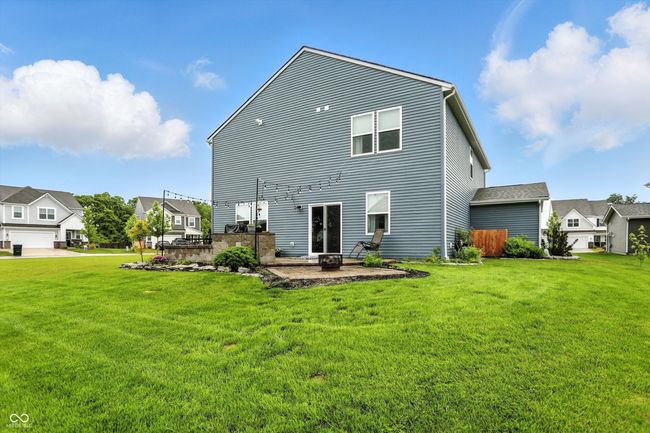 back of property with a patio area, a lawn, and a residential view | Image 42