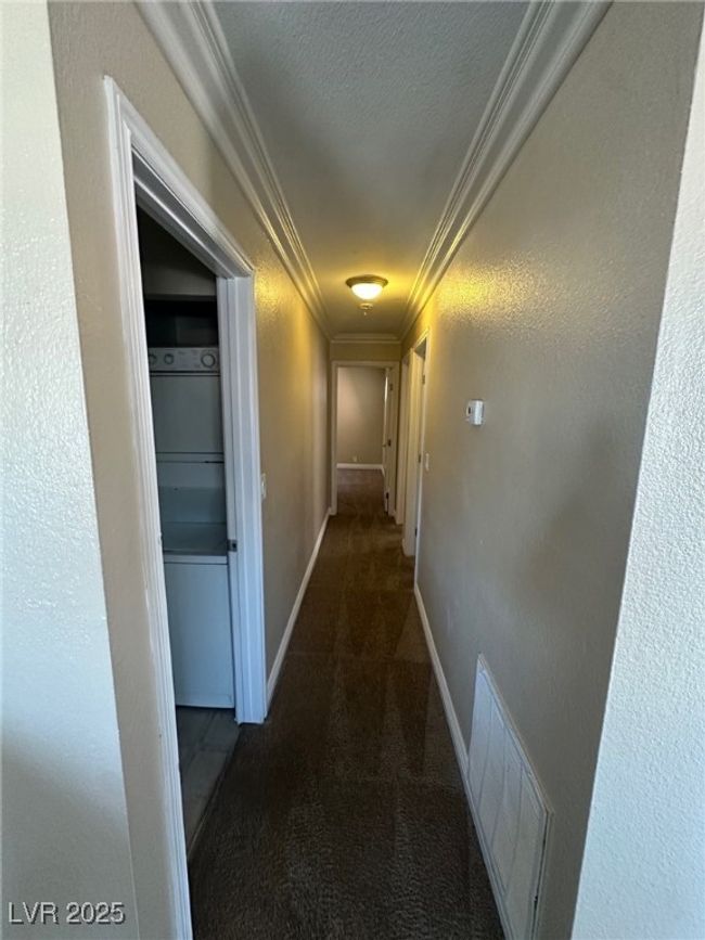 Hall with carpet, baseboards, visible vents, a textured ceiling, and crown molding | Image 9