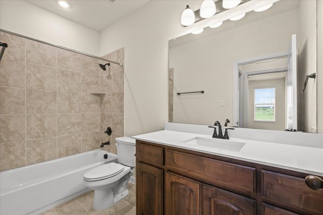 Full bath featuring vanity, washtub / shower combination, and tile patterned flooring | Image 21