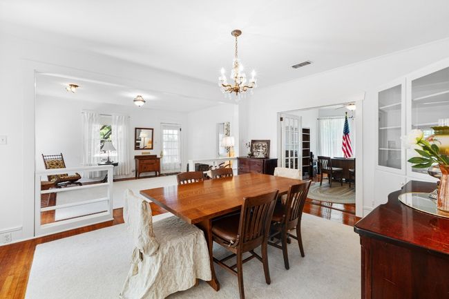 Dining space with wood flooring, a chandelier, and french doors to side porch | Image 10