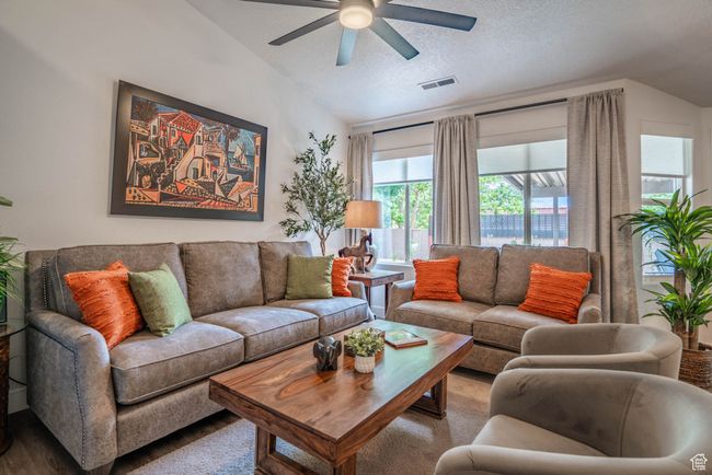 Living room with ceiling fan, vaulted ceiling, a textured ceiling, and hardwood / wood-style floors | Image 27