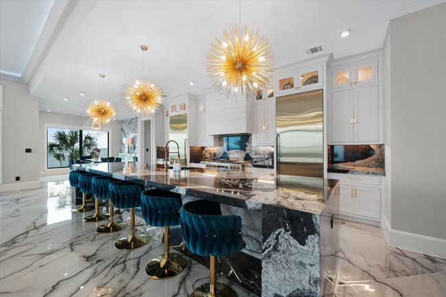 Kitchen featuring visible vents, marble finish floor, backsplash, and built in refrigerator | Image 10
