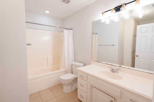 Full bathroom with tile patterned flooring, vanity, and shower / bathtub combination with curtain | Image 21