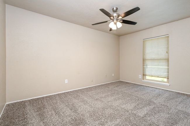 Carpeted empty room featuring baseboards and a ceiling fan | Image 20