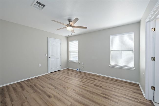 Spare room featuring a ceiling fan, visible vents, light wood finished floors, and baseboards | Image 17
