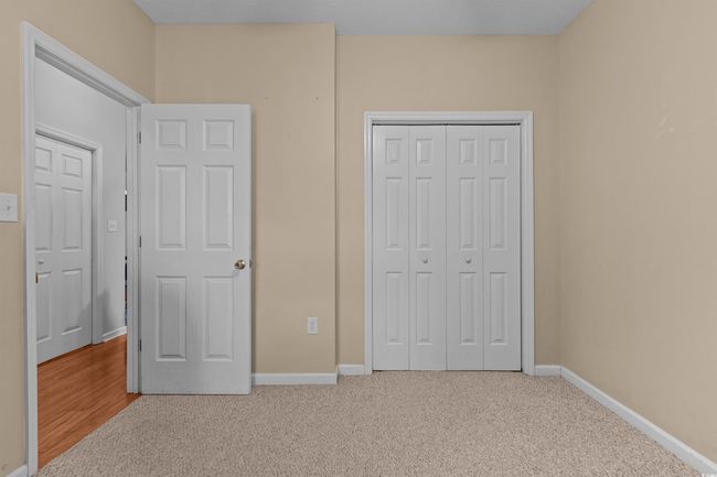 Unfurnished bedroom with carpet flooring, a closet, and baseboards | Image 10