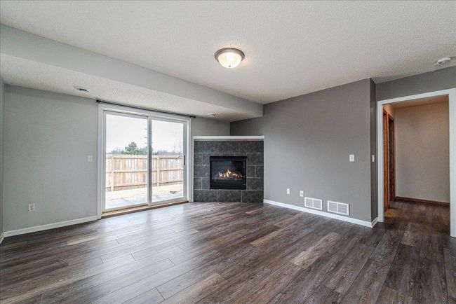 Main Floor Living Room Features Gas Burning Fire Place and Walk Out Patio! | Image 9