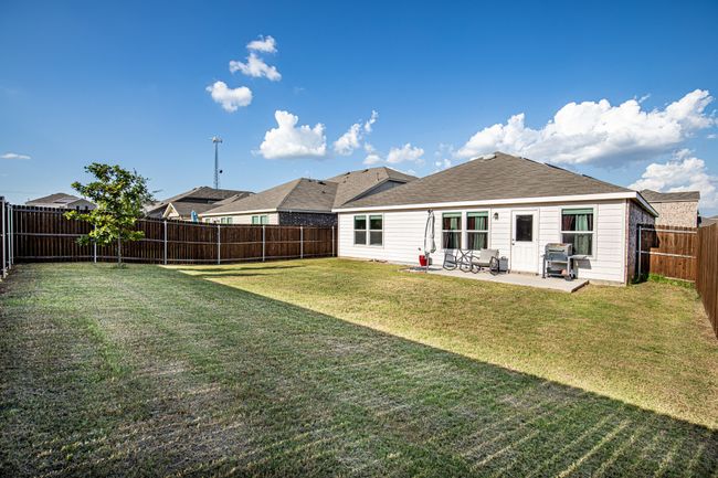 Rear view of property featuring a fenced backyard and a patio area | Image 28