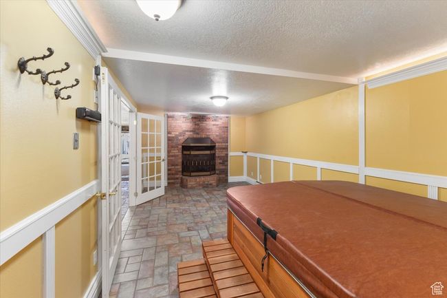 Interior space featuring stone finish flooring, a fireplace, and a textured ceiling | Image 28