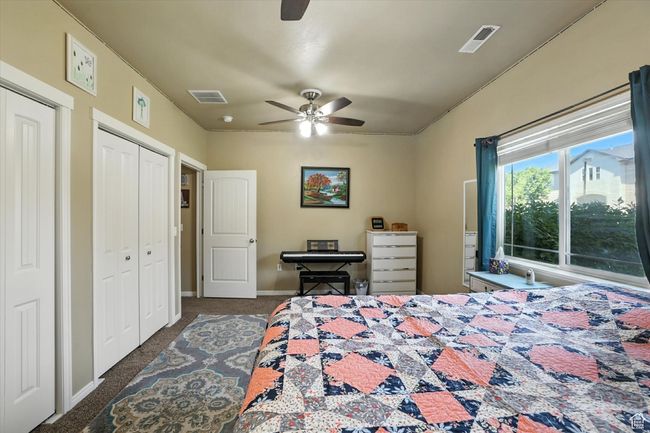 Carpeted bedroom featuring two closets and a ceiling fan | Image 14