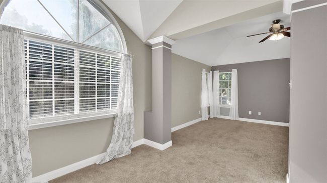 Primary bedroom showing bonus area, with lofted ceiling, carpet, a ceiling fan, and baseboards | Image 13