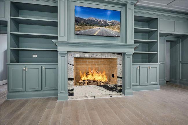 Details featuring wood finished floors, a premium fireplace, and built in features | Image 9