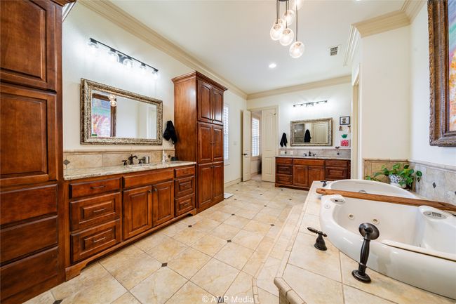 Bathroom with tile patterned flooring, vanity, a bathing tub, and ornamental molding | Image 24