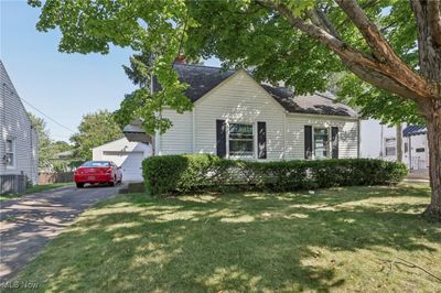 View of front of home featuring a front lawn, a garage, and central AC | Image 3