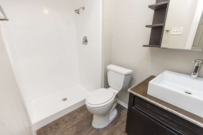 Bathroom with vanity, wood finished floors, toilet, and a shower stall | Image 23