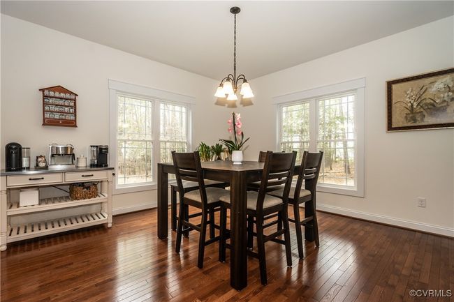 Dining space with an inviting chandelier, dark wood-style flooring, and baseboards | Image 9